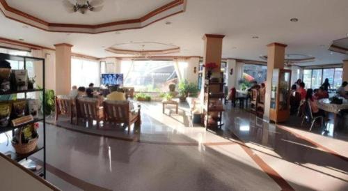 a lobby with people sitting in chairs in a building at Ritzy House Hotel in Chumphon
