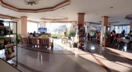 a lobby with people sitting in chairs in a building at Ritzy House Hotel in Chumphon