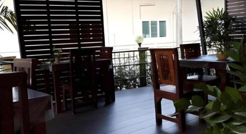 a patio with a table and chairs and a balcony at Ritzy House Hotel in Chumphon