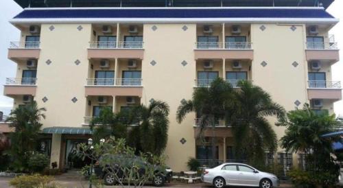 a building with a car parked in front of it at Ritzy House Hotel in Chumphon