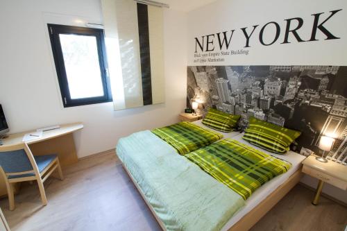 een slaapkamer met een bed en een bord uit New York aan de muur bij Boardinghouse-Ebenhausen in Ebenhausen Werk