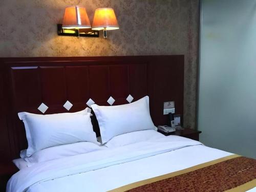 a bedroom with a large bed with white pillows at Shell Hotel Taiyuan South Railway Station New Southeast Bus Station in Taiyuan