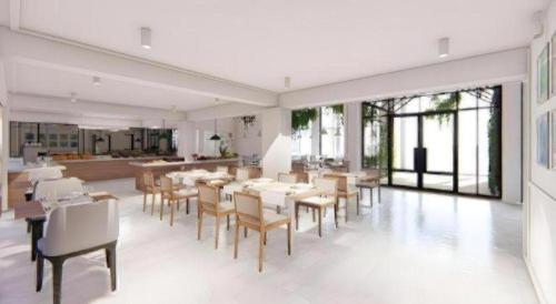 a dining room with tables and chairs and windows at Thaisun Bangkok Hotel in Bangkok