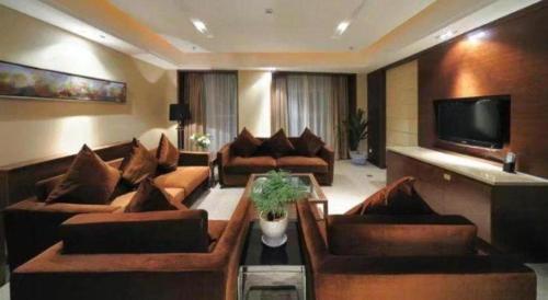 a living room with couches and a flat screen tv at Holiday Inn Hotel & Suites Jiaxing Hangzhou Bay By IHG in Jiaxing