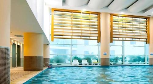 a swimming pool in a building with a large window at Holiday Inn Hotel & Suites Jiaxing Hangzhou Bay By IHG in Jiaxing