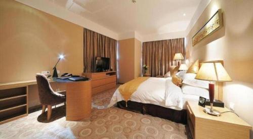 a hotel room with a bed and a desk and a computer at Holiday Inn Hotel & Suites Jiaxing Hangzhou Bay By IHG in Jiaxing