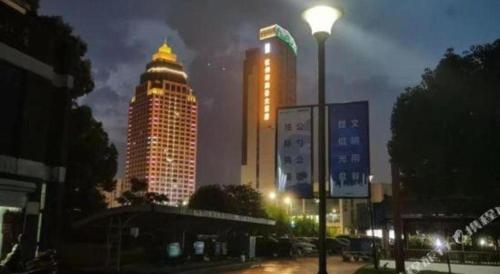 a lit up city at night with tall buildings at Holiday Inn Hotel & Suites Jiaxing Hangzhou Bay By IHG in Jiaxing