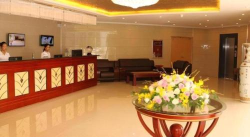 a lobby with a waiting room with flowers in the foreground at GreenTree Inn Jiangsu Xuzhou Jinshan Bridge Building Jinqiao Road Express Hotel in Xuzhou