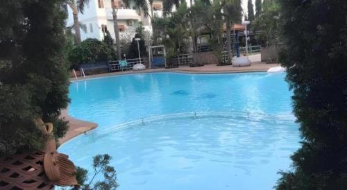 a large blue swimming pool in a hotel at Hihotel Saraburi in Sara Buri