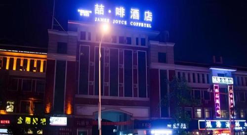 a street light in front of a building at night at James Joyce Coffetel·Suqian Bus Station in Suqian