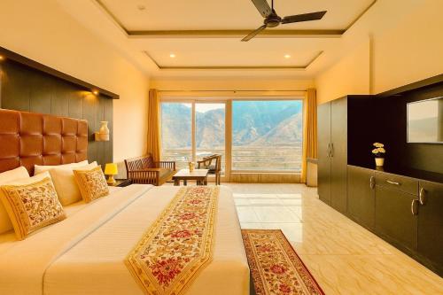 Un dormitorio con una cama grande con una ventana grande. en The kempty Fall Resort, Mussoorie - Lavish & Luxury Stay, en Mussoorie
