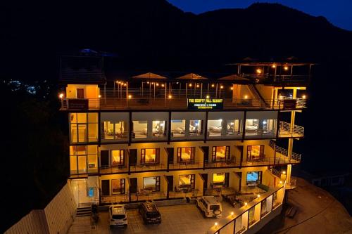 Un edificio con coches aparcados delante por la noche. en The kempty Fall Resort, Mussoorie - Lavish & Luxury Stay, en Mussoorie