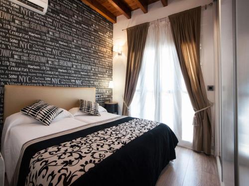 um quarto com uma cama e uma parede de tijolos em Singular Siete Revueltas em Sevilha