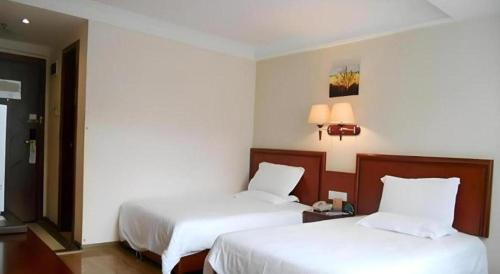 two beds in a hotel room with white sheets at GreenTree Inn Nanning Langdong Hotel in Nanning