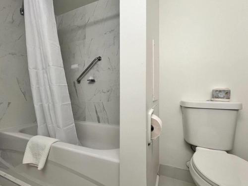 a bathroom with a toilet and a tub and a sink at Econo Lodge Motel Village in Calgary