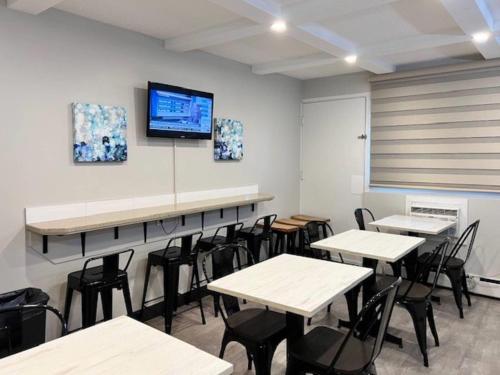 a classroom with tables and chairs and a tv on the wall at Econo Lodge Motel Village in Calgary
