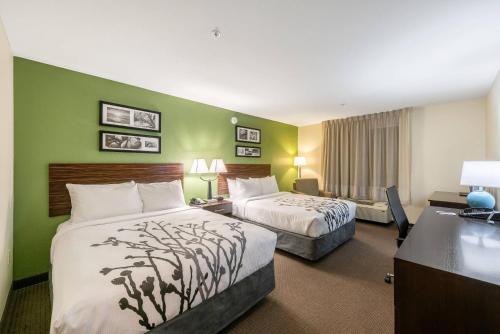 a hotel room with two beds and a desk at Sleep Inn & Suites Ruston Near University in Ruston
