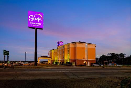 a sign for a hotel on the side of a street at Sleep Inn & Suites Ruston Near University in Ruston