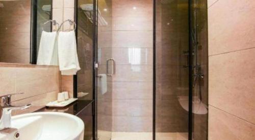 a bathroom with a glass shower and a sink at Cozy Hotel Xiamen in Xiamen
