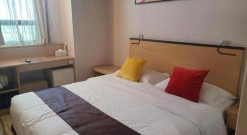 a bedroom with a bed with three pillows on it at Cozy Hotel Xiamen in Xiamen