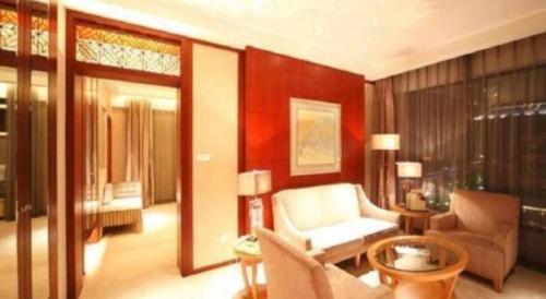 a living room with a couch and a chair at Ramada Plaza by Wyndham Yangzhou Casa in Yangzhou