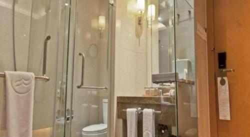 a bathroom with a glass shower and a toilet at Ramada Plaza by Wyndham Yangzhou Casa in Yangzhou