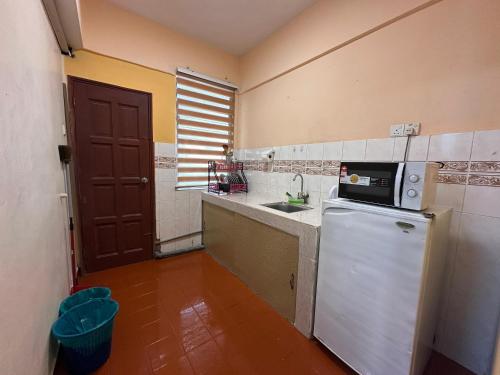 a small kitchen with a sink and a microwave at Glory Beach SeaView 3BR NextLvl Homestay in Port Dickson