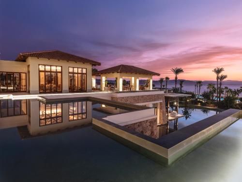 a villa with a swimming pool at night at Grecotel LUXME Kos in Kos Town