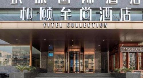 a building with a sign on the front of it at Yitel Collection Lianyungang High-speed Railway Station Suning Plaza in Lianyungang