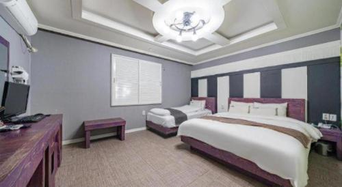 a large bedroom with two beds and a chandelier at Luxury Motel Daejeon in Daejeon