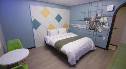 a small bedroom with a bed and a table at Luxury Motel Daejeon in Daejeon