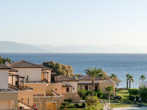 a view of houses with the ocean in the background at Grecotel LUXME Kos in Kos Town