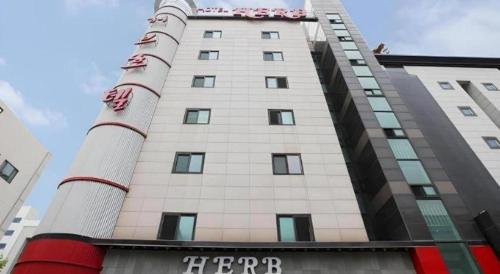 a tall white building with a sign on it at Hotel Casa Suwon in Suwon