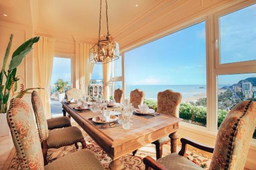 a dining room with a table and chairs and a large window at The IMPERIAL Vung Tau Hotel in Vung Tau