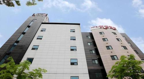 a tall white building with two towers at Hotel Casa Suwon in Suwon