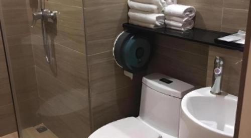 a bathroom with a toilet and a shower and a sink at Hanyong Hotel Shenzhen International Exhibition Center in Shenzhen