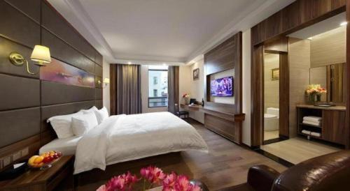 a bedroom with a large bed and a bathroom at Hanyong Hotel Shenzhen International Exhibition Center in Shenzhen