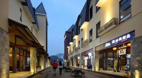 a group of people walking down a street with buildings at Hanyong Hotel Shenzhen International Exhibition Center in Shenzhen