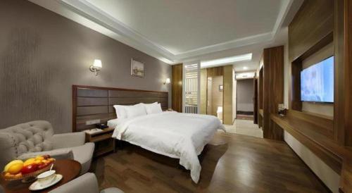 a hotel room with a bed and a television at Hanyong Hotel Shenzhen International Exhibition Center in Shenzhen