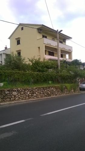 a building on the side of a road at Lovrić Apartments in Baška