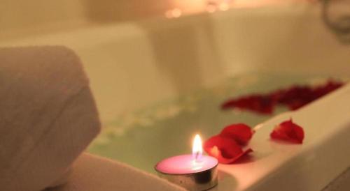 a candle with two roses in a bath tub at Midland Hotel in Phnom Penh