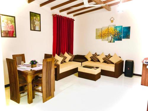 a living room with a couch and a table at Serenity Stay in Nikawatawana