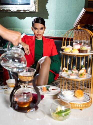 a woman sitting in front of a table with food at The IMPERIAL Vung Tau Hotel in Vung Tau