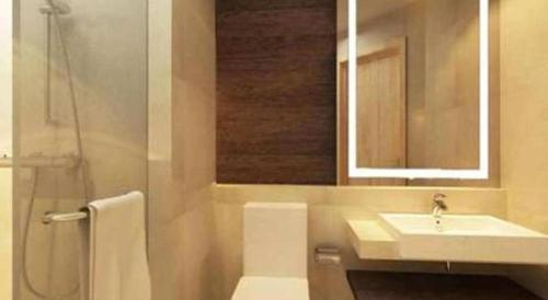 a bathroom with a sink and a toilet and a mirror at Hotel Grandhika Pemuda in Semarang