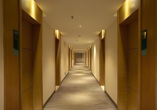 a hallway of a building with a long corridor at City Comfort Inn Nanning Zoo Keyuan Avenue in Nanning