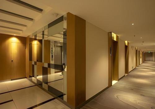 a hallway of a building with wooden walls and glass doors at City Comfort Inn Nanning Zoo Keyuan Avenue in Nanning