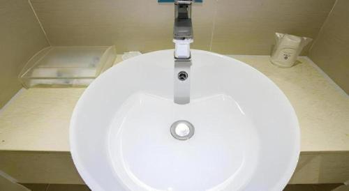 a white sink with a faucet in a bathroom at City Comfort Inn Nanning Zoo Keyuan Avenue in Nanning