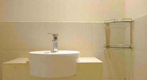 a white bathroom with a sink and a mirror at City Comfort Inn Nanning Zoo Keyuan Avenue in Nanning