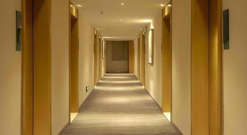 a long hallway with yellow walls and a long hallwayngth at City Comfort Inn Nanning Zoo Keyuan Avenue in Nanning