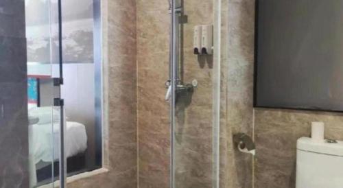 a bathroom with a glass shower with a toilet at Guilin Manhatton Hotel Tianjie in Guilin